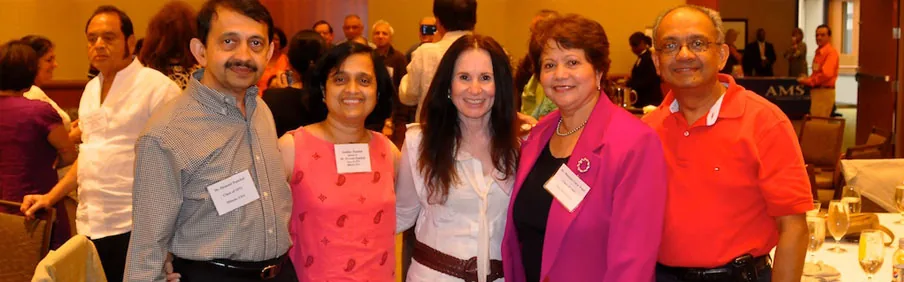 Smiling alumni posing together at a reunion dinner