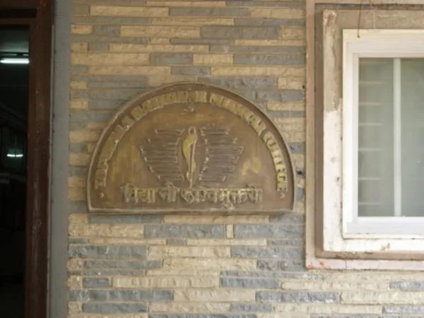 The TNMC emblem plaque on the college wall